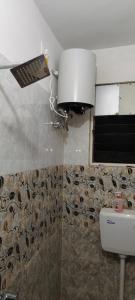 Un baño con inodoro y una luz en la pared. en Royal inn, en Patna