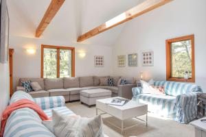 a living room with blue and white furniture and windows at 15 Min Walk to Beach w Kayaks in Wellfleet