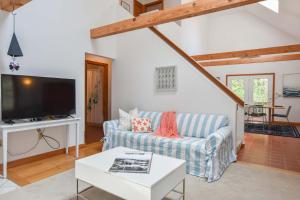 a living room with a couch and a tv at 15 Min Walk to Beach w Kayaks in Wellfleet