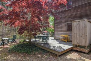 a wooden deck with a table and chairs next to a tree at 15 Min Walk to Beach w Kayaks in Wellfleet