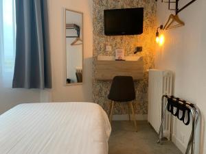Un dormitorio con una cama y un televisor en una pared. en Hôtel Le Keroman, en Lorient