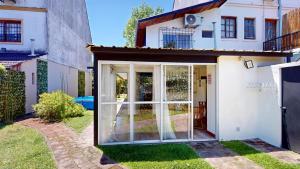 a house with sliding glass doors in a yard at Casa Tipo Loft- Tigre Centro Con Jardin, Parrilla - 4 Personas in Tigre