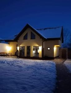 a house with snow in front of it at night at Conacul lui Radu in Făgăraş