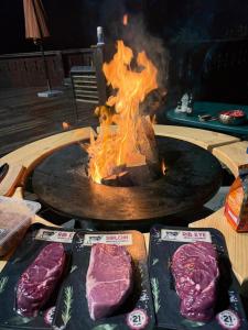 a grill with some meat and a fire at Conacul lui Radu in Făgăraş