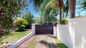 a gate to a backyard with a white fence at Casa Tipo Loft- Tigre Centro Con Jardin, Parrilla - 4 Personas in Tigre +23 photos