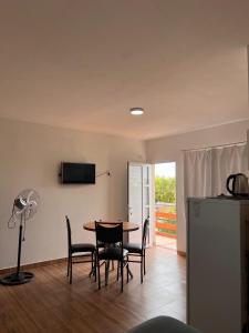 een keuken en eetkamer met een tafel en stoelen bij Brusa in Las Grutas