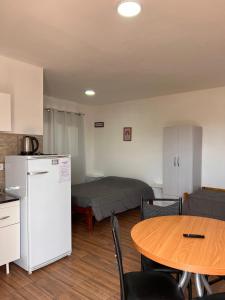 een kamer met een keuken, een tafel en een koelkast bij Brusa in Las Grutas