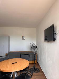 een kamer met een tafel en een tv aan de muur bij Brusa in Las Grutas