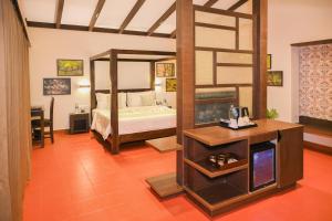 a bedroom with a bed and a television in a room at Nirjhara Coorg in Somvārpet +42 photos