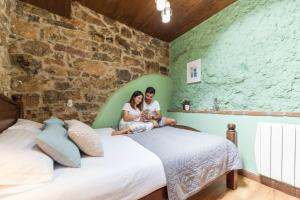 a man and woman sitting on a bed in a room at Montegrande, entorno mágico rodeado de montañas in La Plaza