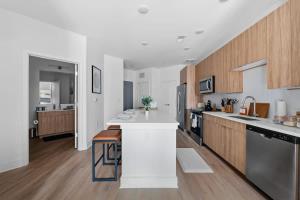 una grande cucina con banconi bianchi e armadi in legno di Luxury Downtown Property With a Pool a Birmingham