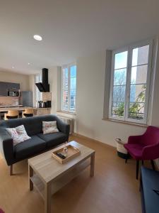 ein Wohnzimmer mit einer Couch und einem Couchtisch in der Unterkunft Les Appartements de La Maison Verneuil in Paray-le-Monial
