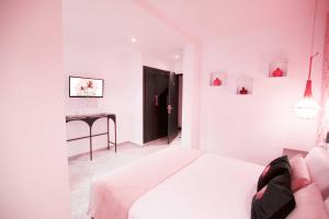 a white bedroom with a bed and a desk at Riad La Petite Majorelle in Marrakesh
