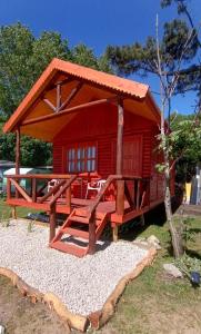 Una pequeña cabaña roja con techo en la parte superior. en Kiya surf cabaña, en Colonia Chapadmalal