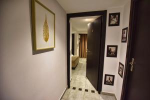 a hallway with a black door and pictures on the walls at Riad La Petite Majorelle in Marrakesh