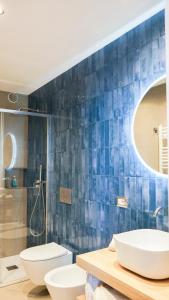 a bathroom with two toilets and a blue tiled wall at Palazzo Cettina Sul Mare in Cefalù +137 photos