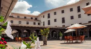 a courtyard with tables and chairs and a building at Hilton Garden Inn Cusco in Cusco