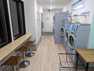 eine Waschküche mit Waschmaschinen und Trocknern in der Unterkunft Laundry Design House 妙典駅6分 in Ichikawa