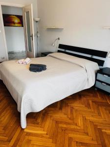 a bedroom with a large bed and a wooden floor at Traiano 49 in Turin