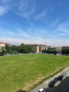 a large field with cars parked on the side of a road at Traiano 49 in Turin