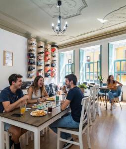 a group of people sitting at a table in a restaurant at Invictus Hostel in Porto
