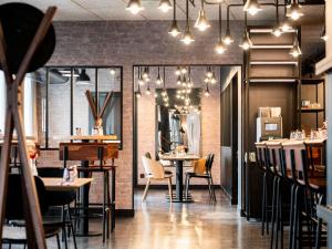 ein Restaurant mit Tischen und Stühlen und einer Backsteinmauer in der Unterkunft Ibis Styles Lyon Villeurbanne Parc de la Tête d'Or in Villeurbanne + 95 Fotos