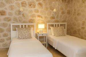 two beds in a room with a stone wall at Villa Ilda - Deluxe Holiday Villa - KALKAN-ANTALYA in Kalkan +59 photos