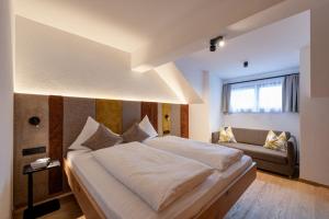 a bedroom with a large bed and a couch at Hotel Garni Mirabell in Ischgl +49 photos