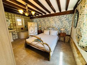 ein Schlafzimmer mit einem Bett in einem Zimmer in der Unterkunft Chambres d'hôtes accès au spa in Lieurey