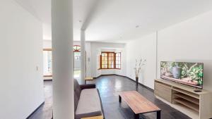 a living room with a tv and a wooden table at Casa Amplia 5 personas Con Pileta, Amplio Jardin y Parrilla Zona Muy Tranquila en Tigre Centro in Tigre