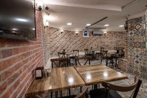 ein Restaurant mit Holztischen, Stühlen und Ziegelwänden in der Unterkunft Family Istanbul Hotel in Istanbul