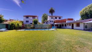 a yard with a large lawn in front of a house at Casa Amplia 5 personas Con Pileta, Amplio Jardin y Parrilla Zona Muy Tranquila en Tigre Centro in Tigre