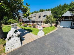 Eine Statue zweier Frauen auf einer Auffahrt vor einem Haus in der Unterkunft Chambres d'hôtes accès au spa in Lieurey