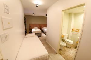 a hospital room with two beds and a toilet at Casa Be Suites in Rosario +42 photos