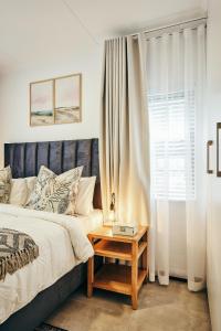 Stylish 1 Bed Garden Unit Power Backup في Sandton: غرفة نوم بسرير وطاولة بجانب نافذة +33 صورة