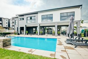a house with a swimming pool and a building at Stylish 1 Bed Garden Unit Power Backup in Sandton