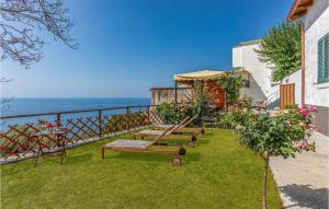 a garden with a bench and the ocean in the background at Villa Degli Ulivi in Furore