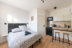a bedroom with a bed and a kitchen with a counter at Casa 159 - SAINT QUENTIN in Saint-Quentin