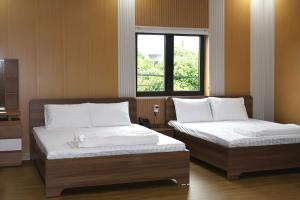 two beds sitting next to each other in a room at Hotel Cốc Cốc 2 in Ấp Rạch Mẹo