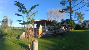 Un pequeño cobertizo con una tabla de surf en el césped. en Kiya surf hostel, en Colonia Chapadmalal 8 fotos más