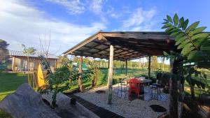 Una pérgola con una mesa y sillas en un jardín. en Kiya surf hostel, en Colonia Chapadmalal