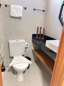 a bathroom with a white toilet and a sink at Villas do Porto Residence by La Playa in Porto De Galinhas