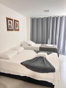 two beds in a room with a window at Villas do Porto Residence by La Playa in Porto De Galinhas +111 photos