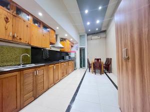 a large kitchen with wooden cabinets and a table at Saigon Quiet Stay in Ho Chi Minh City