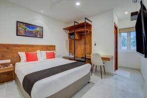 1 dormitorio con 1 cama grande, escritorio y mesa en Arunaa Inn Airport Hotel,Chennai, en Chennai