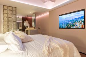 una camera da letto con un letto e una tv a parete di BoH Manila a Medellín