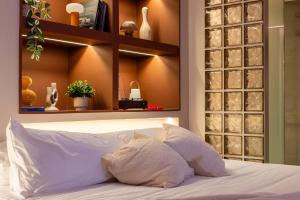 una camera da letto con un letto bianco con una parete con scaffali di BoH Manila a Medellín