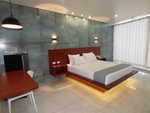 a bedroom with a bed and a table and a desk at OSHO Hotel in Santa Cruz de la Sierra +47 photos