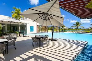 a patio with a table and umbrella next to a swimming pool at Panorama Lake in Punta Cana