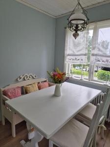 StälldalenにあるFerienhäuschen in Ställdalenの白いダイニングテーブル(花瓶付)